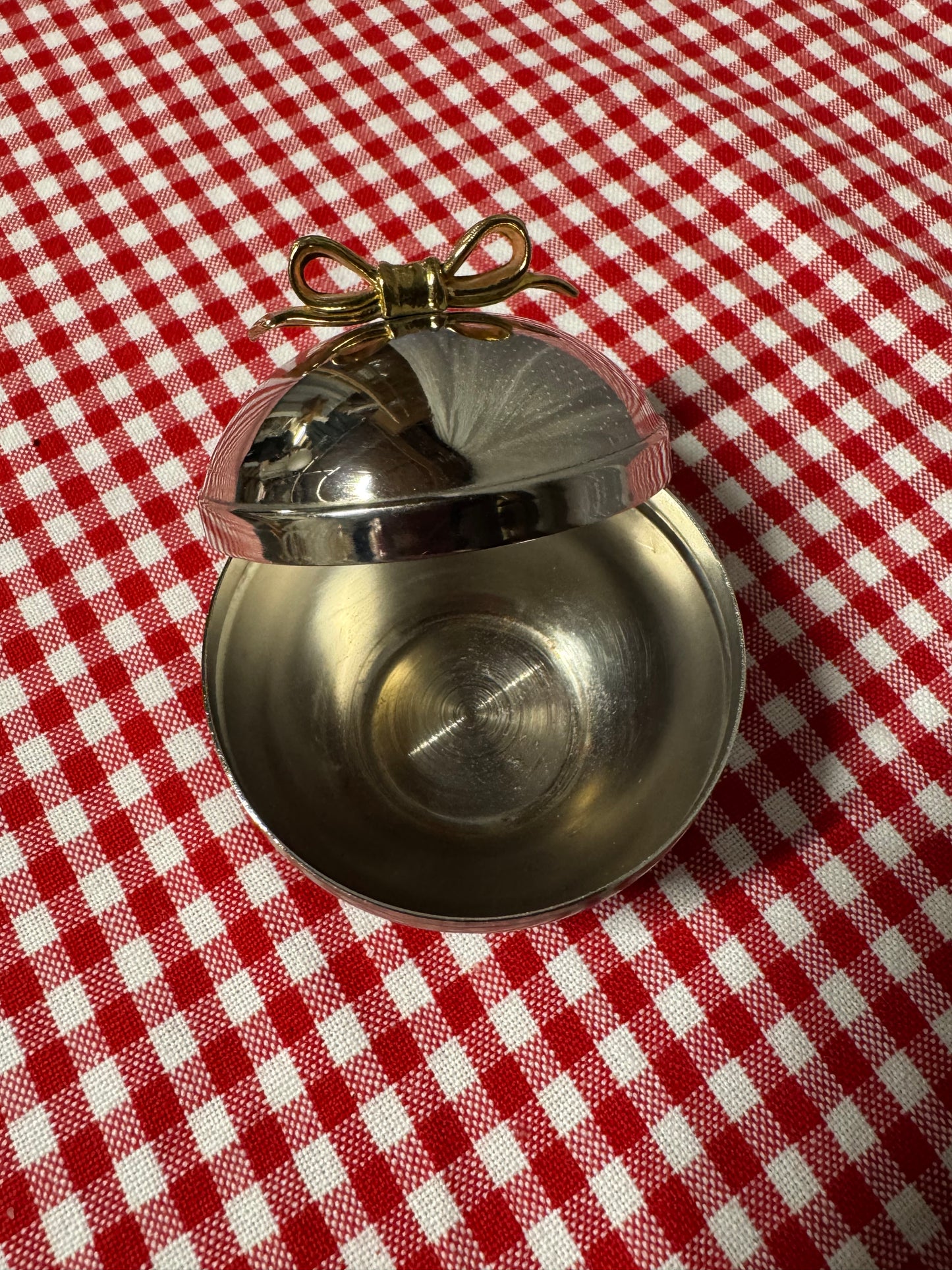 Rund ask i nysilver med guldfärgad rosett