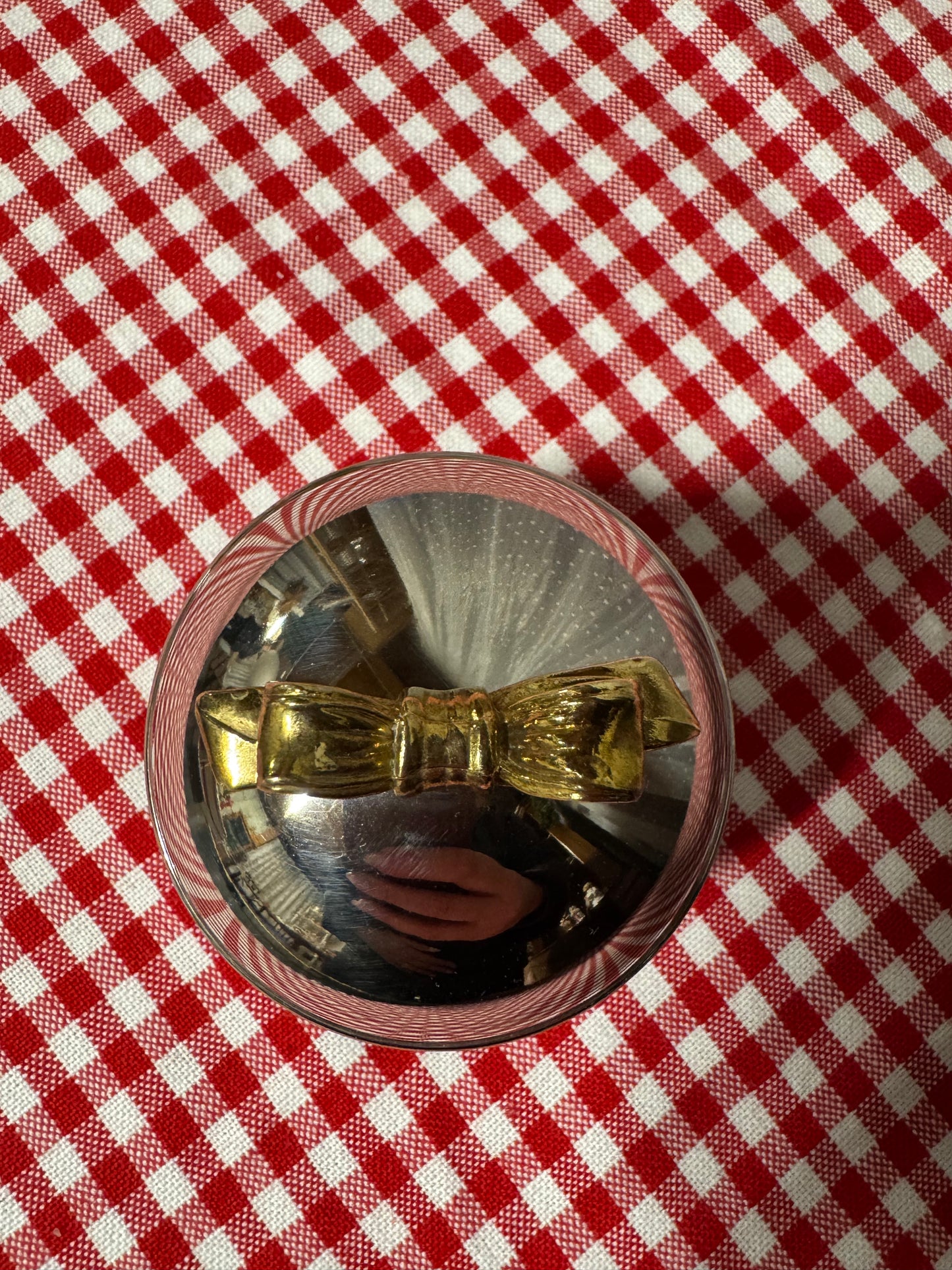 Rund ask i nysilver med guldfärgad rosett