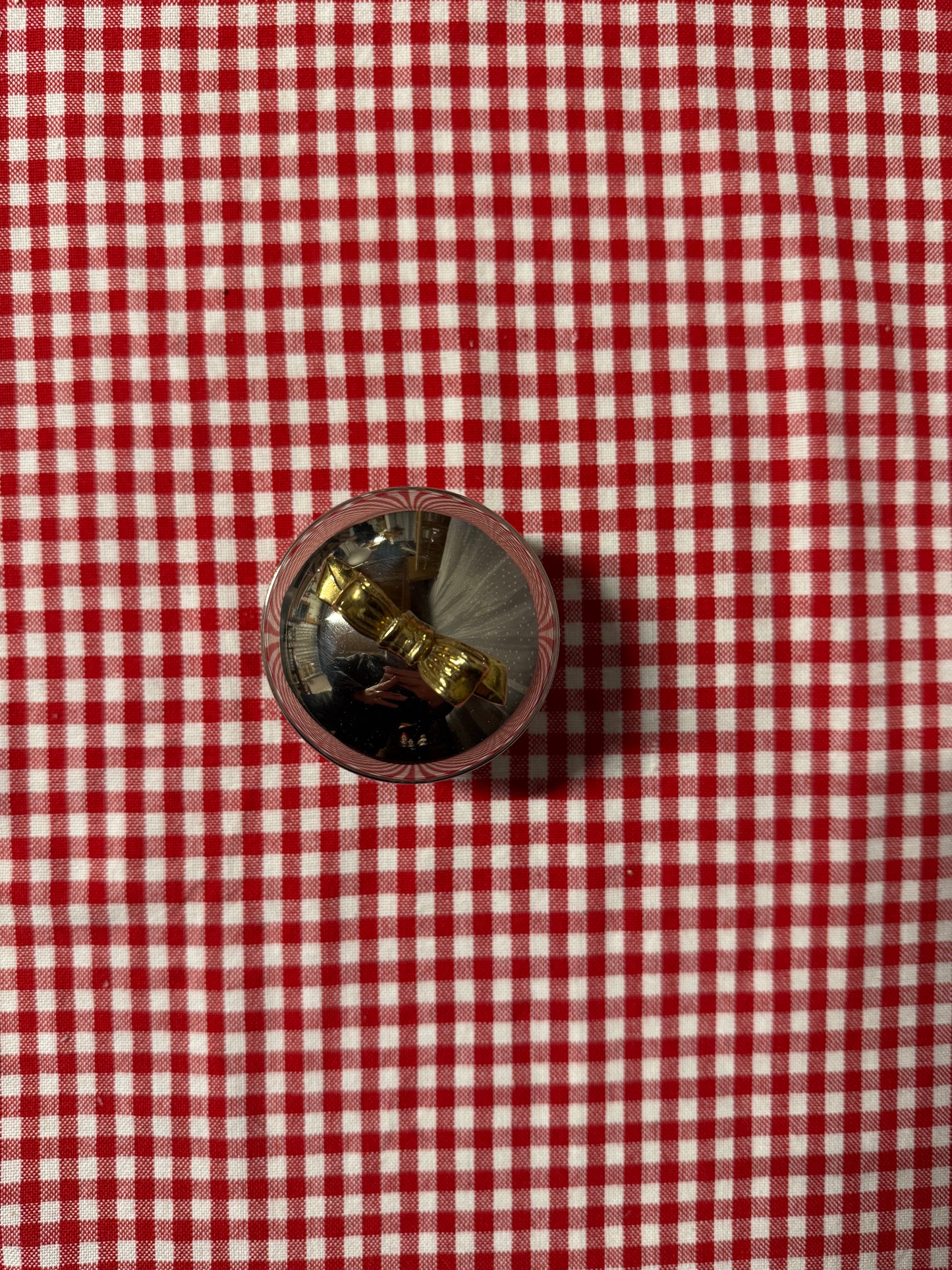 Rund ask i nysilver med guldfärgad rosett