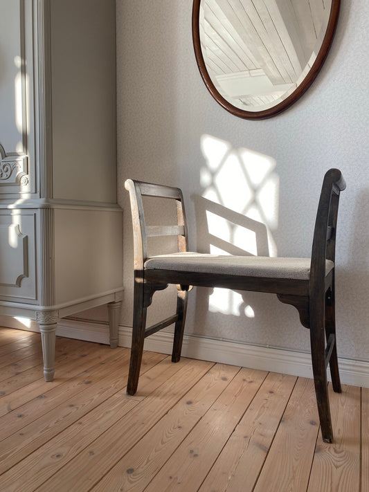 Äldre sittpall i mörkt trä