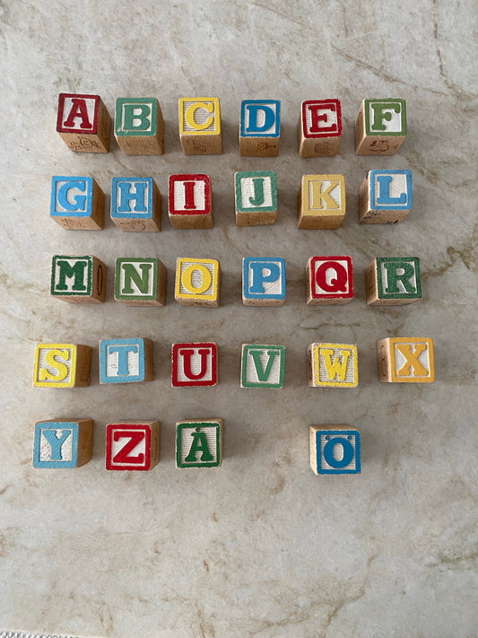 Äldre träklossar med hela alfabetet förutom Ä