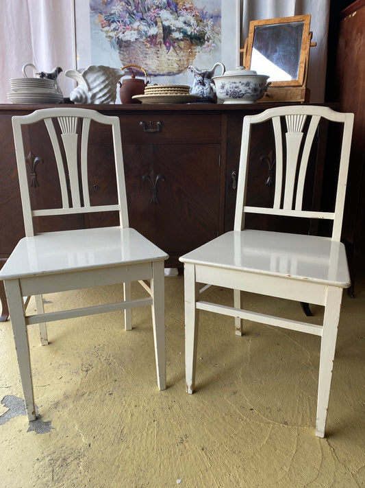 Paret vita gamla trästolar