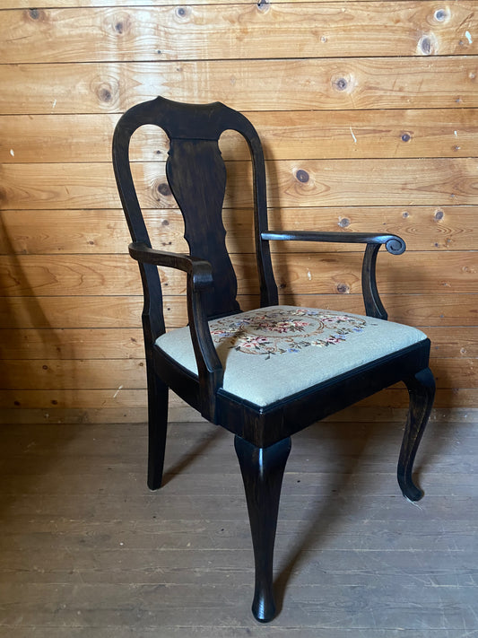 Stor karmstol i mörkt trä med broderad sits