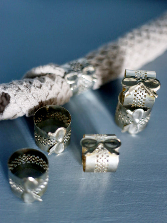 Sex servettringar med rosett i silver