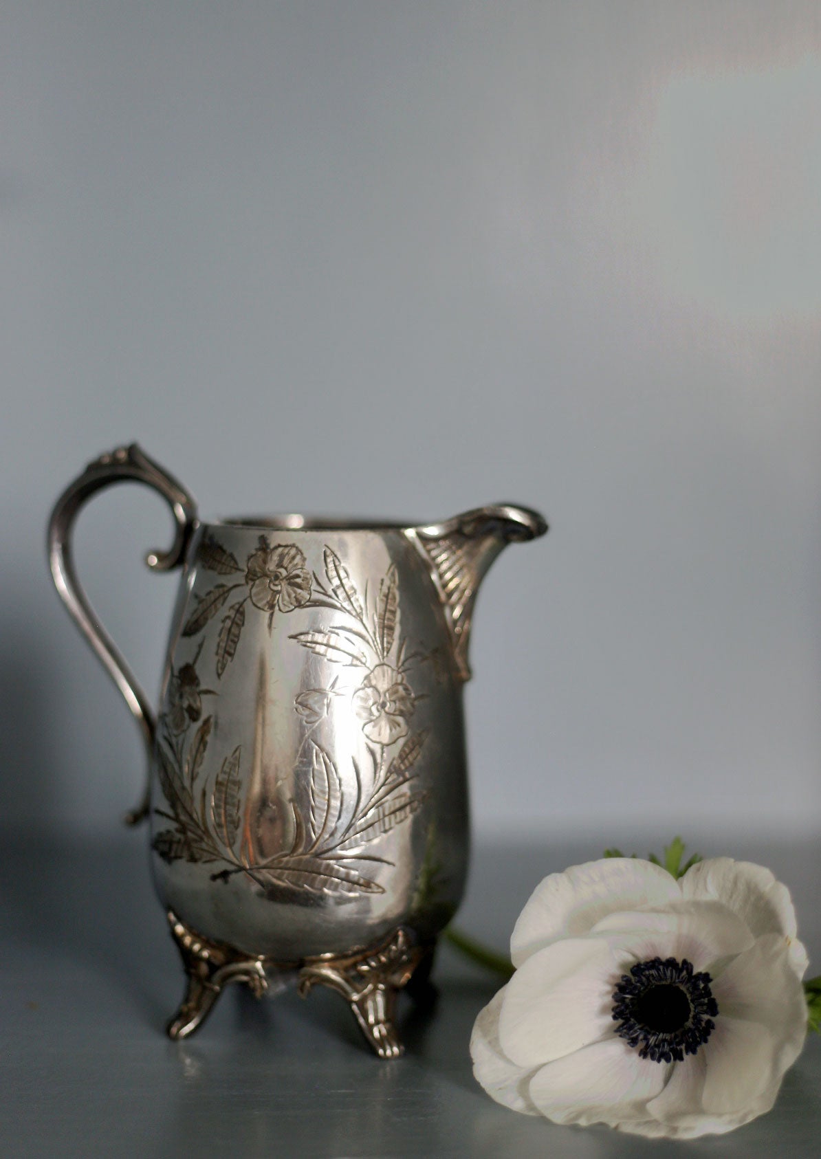 Vas eller mjölkkanna i silver med blommönster