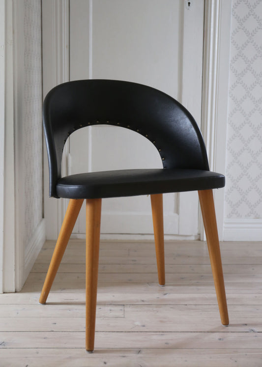 Svart stol i skinnimitation fäst med nitar 50-tal